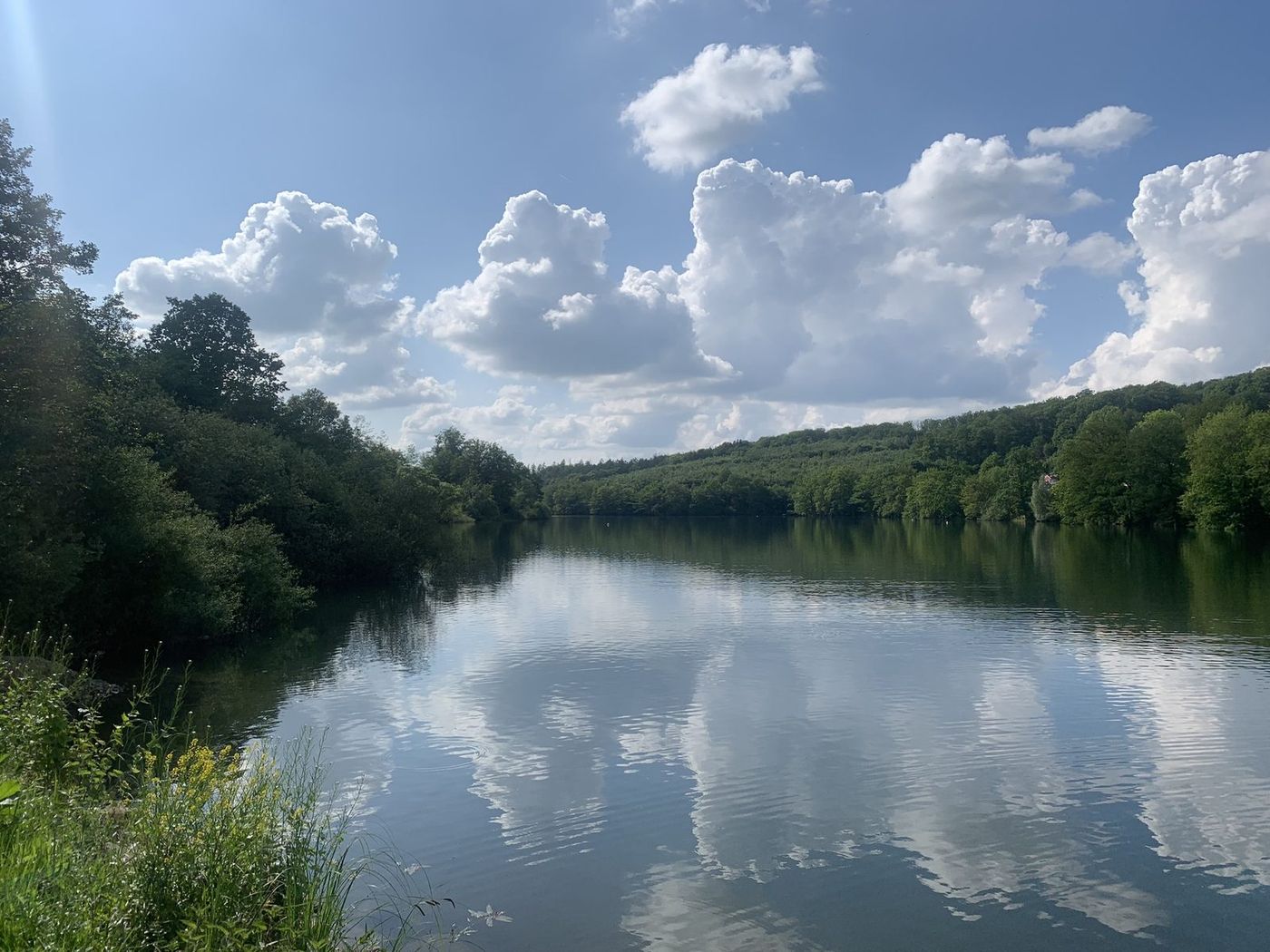 See mit großen weißen Wolken und ihrer Spiegelung